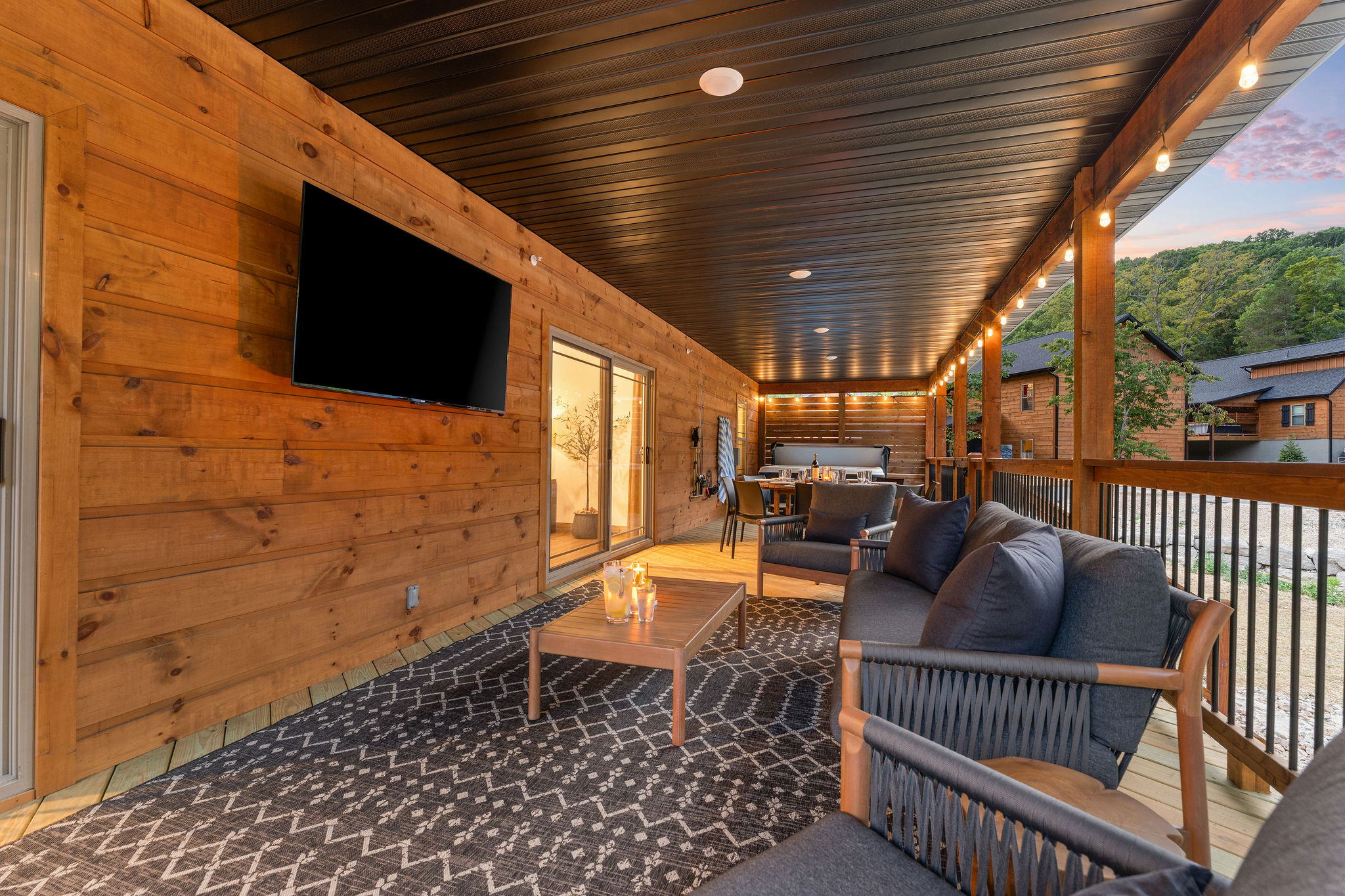 Covered outdoor living deck with TV and seating