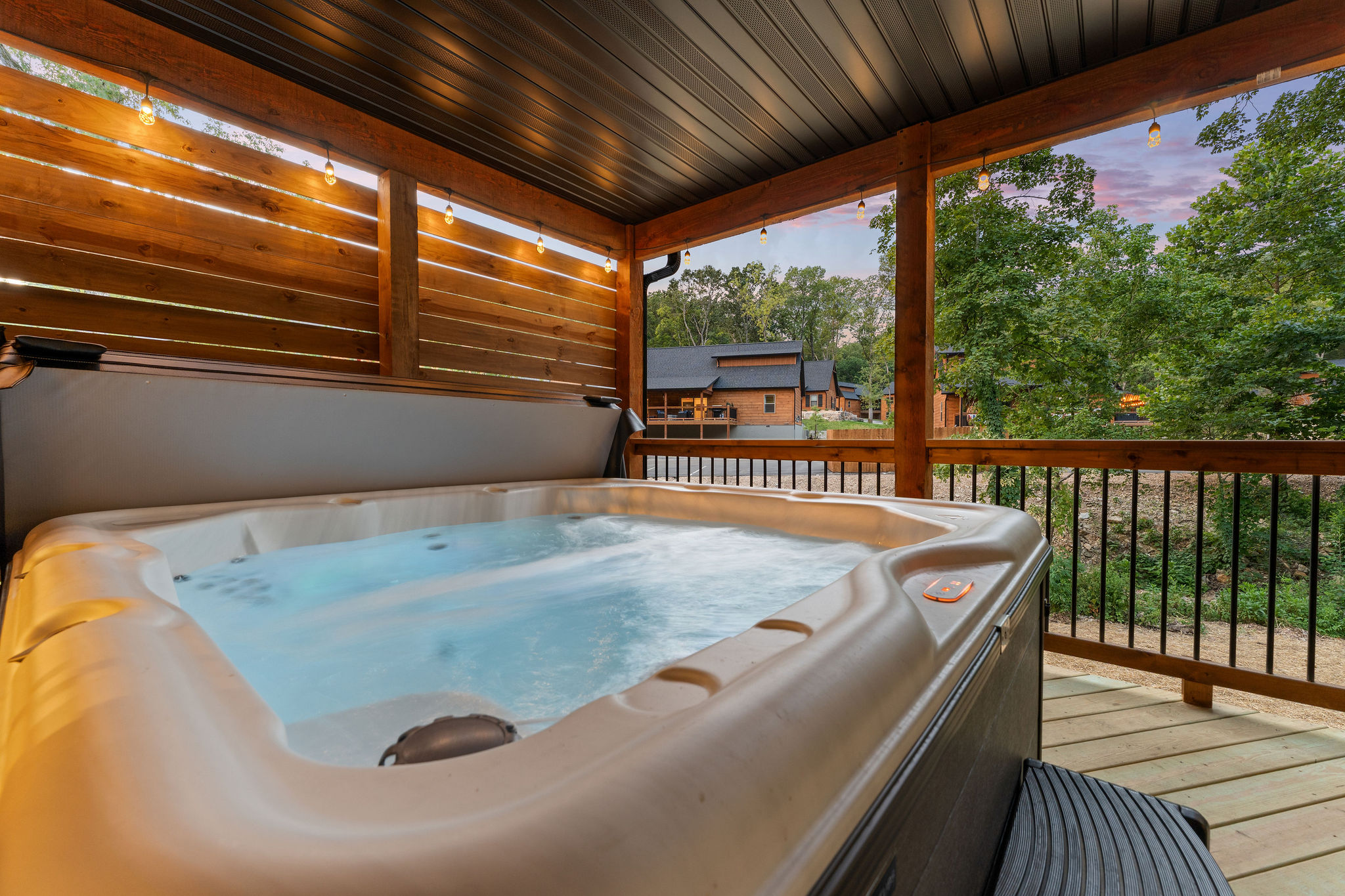 Private hot tub on covered deck at dusk