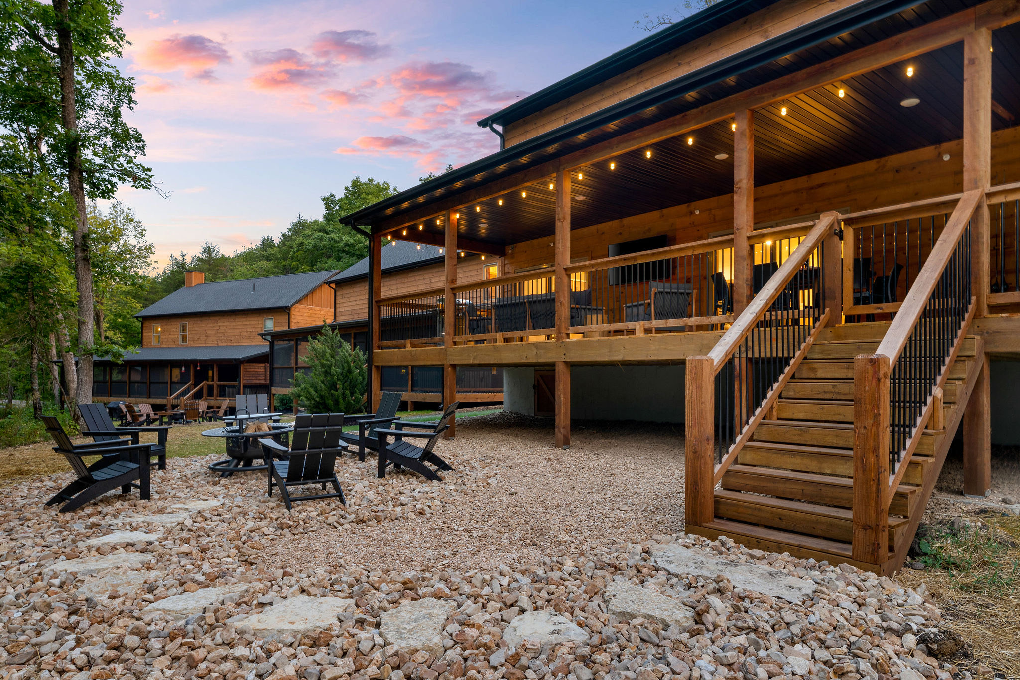 Trailhead Retreat — cabin exterior at dusk with fire pit