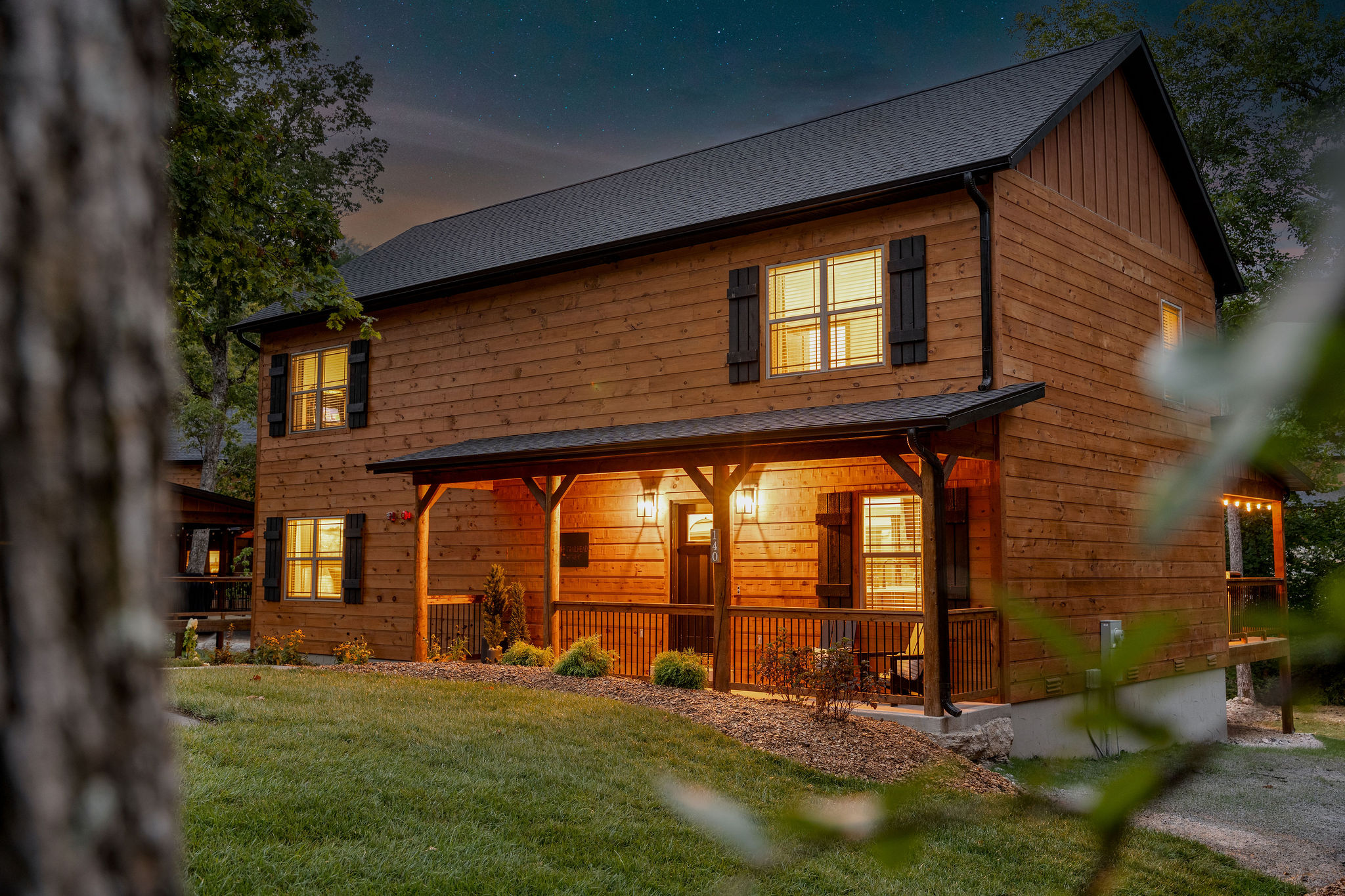 Trailhead Retreat — exterior at night with glowing windows