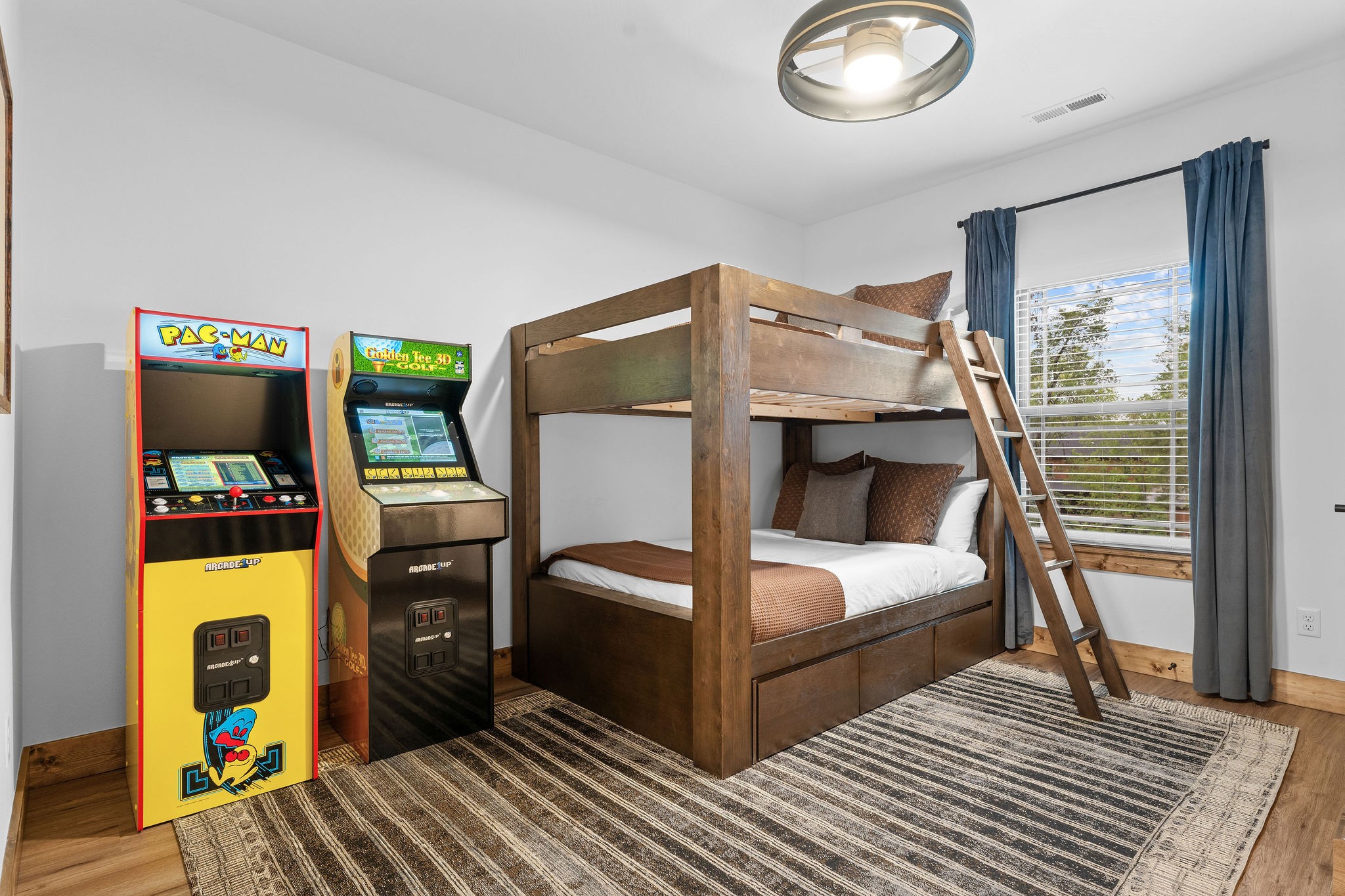 Bunk room with Pac-Man and Golden Tee arcade games
