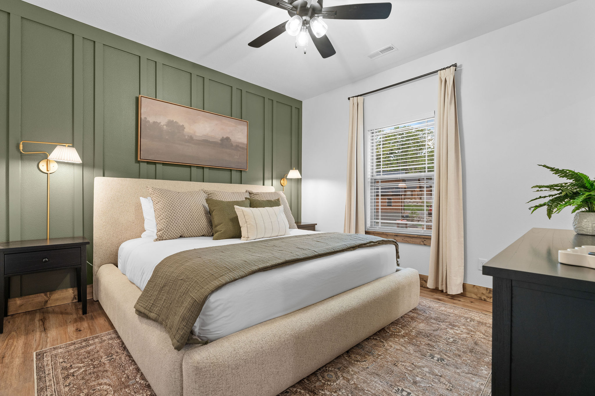 King bedroom with sage green accent wall